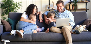 family going online sitting on the sofa