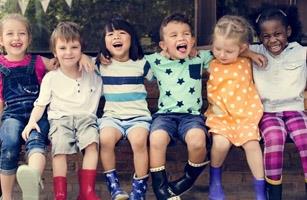 group of young children sitting on a bench