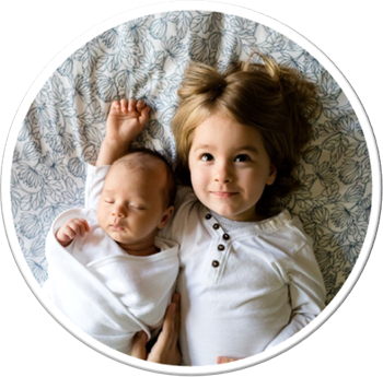 a small child and a baby sleeping in a bed